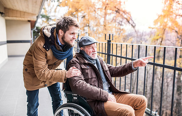 Father in wheelchair and young son on a walk.