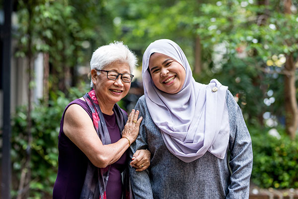 Image of senior woman with caregiver in the street.